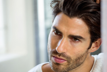Man with dark hair promoting lipostructure fat transfer into face or scalp treatment